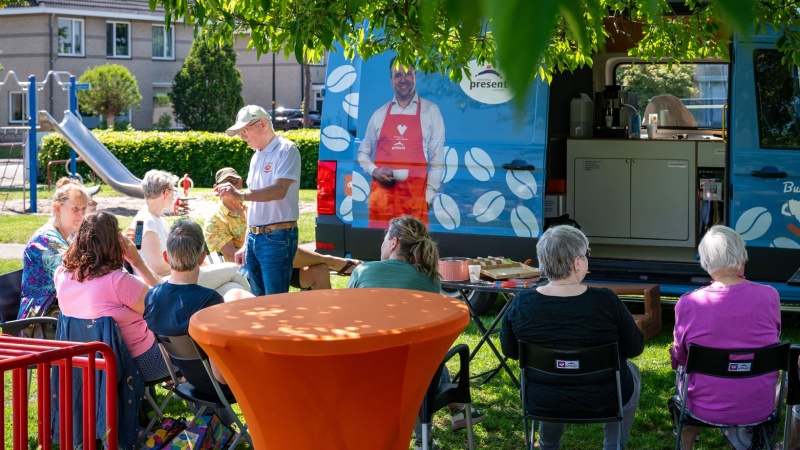 Het terras van de Buurtkoffie is opgezet en een vrijwilliger schenkt koffie en maakt een praatje